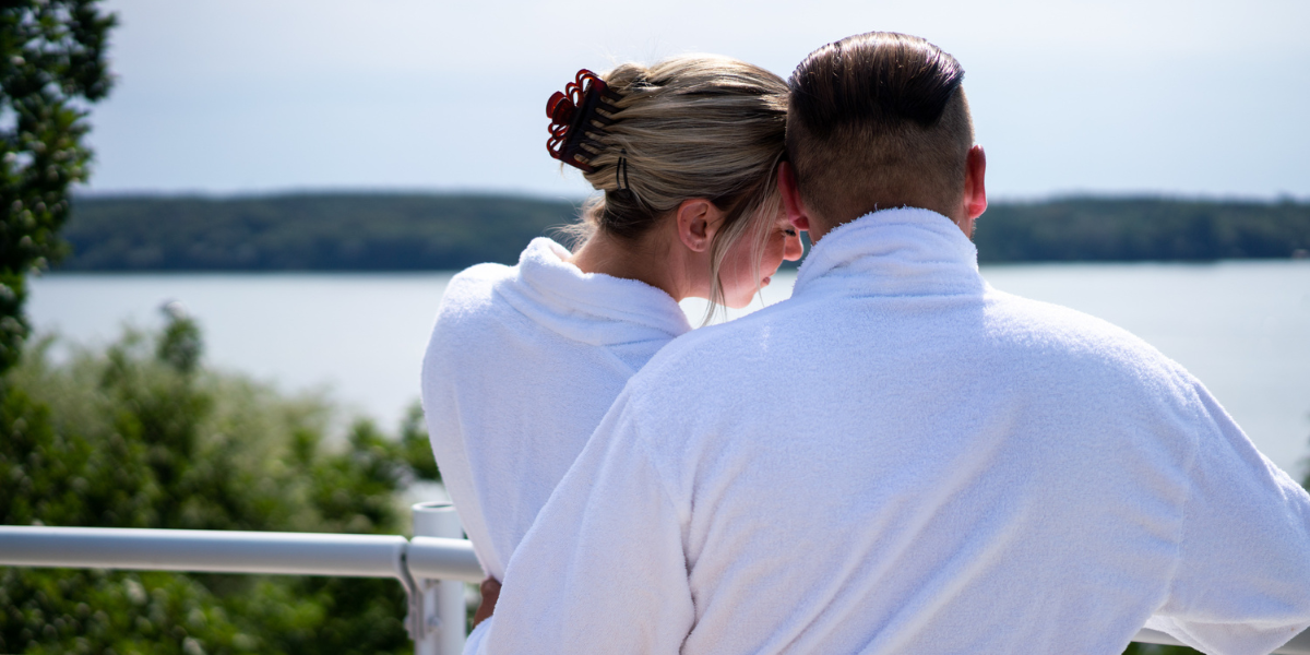 Ein Paar steht auf der Dachterrasse des Kongresshotels und blickt auf den Templiner See
