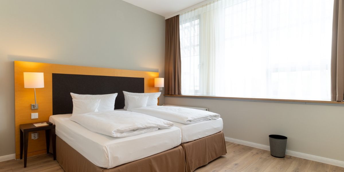 Barrierearmes Studio im Kongresshotel Potsdam. Blick auf das Schlafzimmer mit einem Doppelbett.