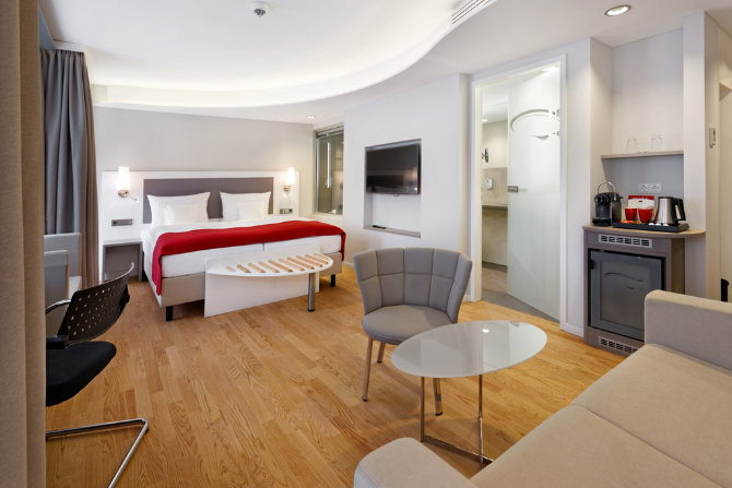 Junior Suite im Kongresshotel Potsdam mit Sitzecke, Doppelbett und moderner Ausstattung.