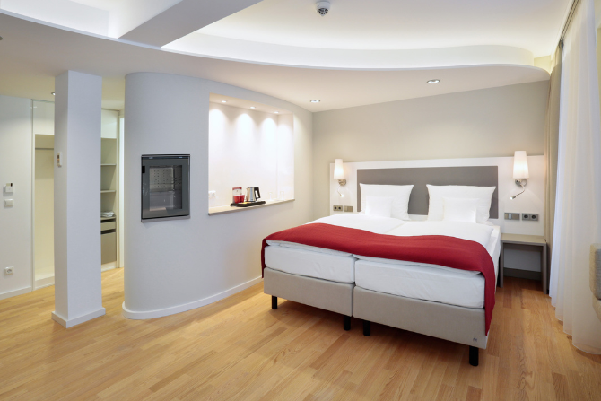Helles Premium-Doppelzimmer im Kongresshotel Potsdam mit Doppelbett und Holzfußboden.