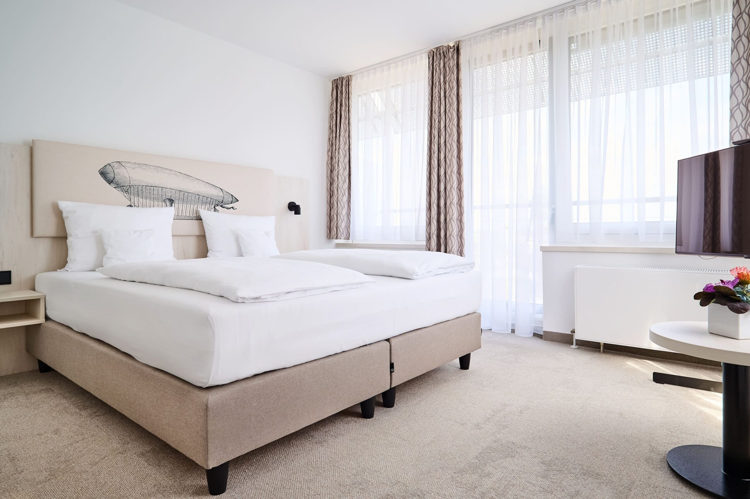 Superior Suite im Kongresshotel Potsdam mit elegantem Doppelbett und Tageslicht