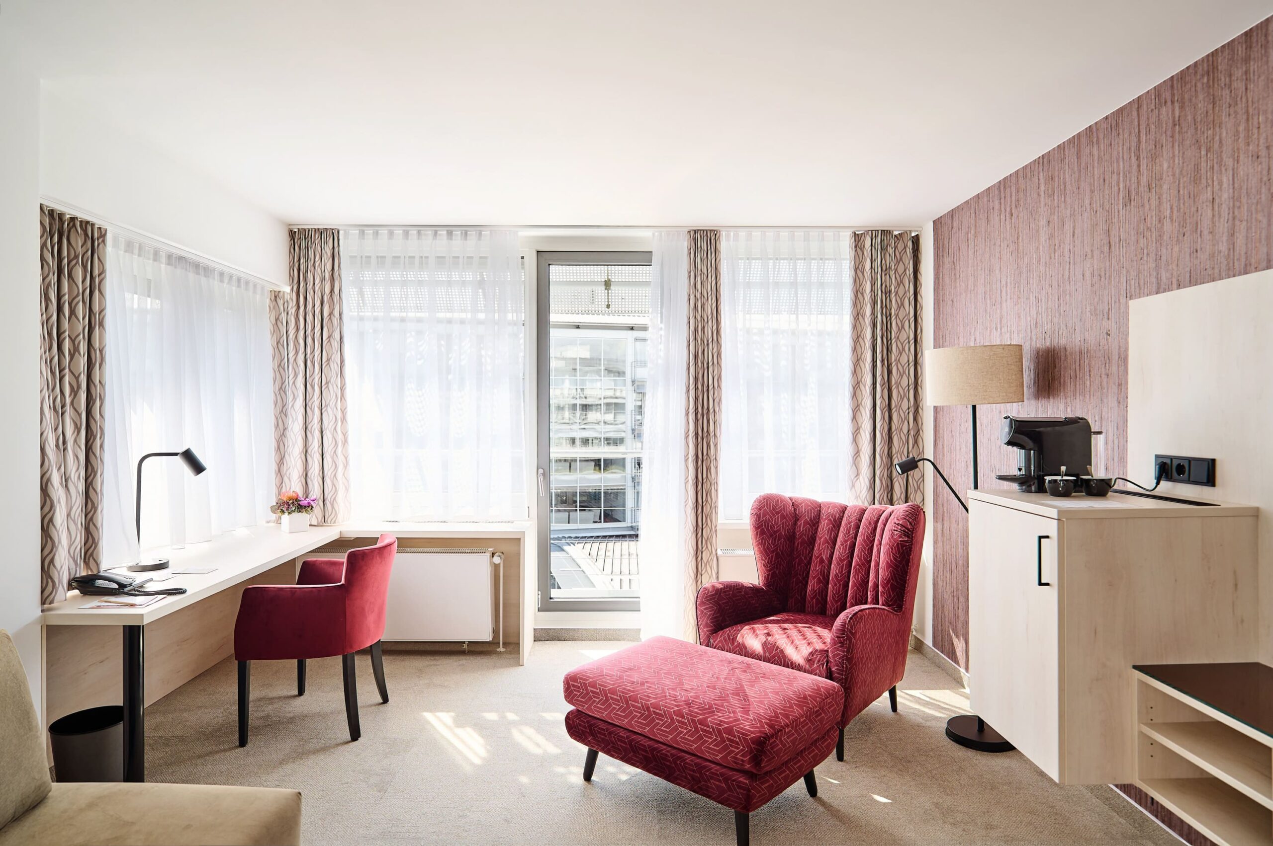 Superior Suite im Kongresshotel Potsdam mit Schreibtisch, Relaxsessel und Balkonzugang.