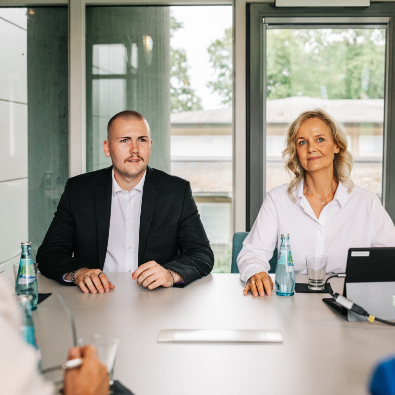 Kongresshotel-Potsdam-Kundengespräch Zwei Personen in Office-Kleidung an einem Tisch.