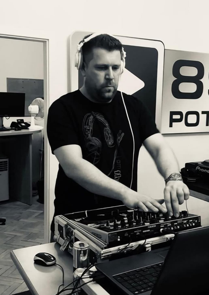 DJ mit Kopfhörern mixt Musik an einem Mischpult.