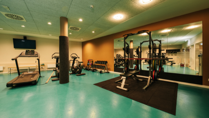 Fitnessraum mit Laufband, Hanteln und Kraftgeräten im Kongresshotel Potsdam.